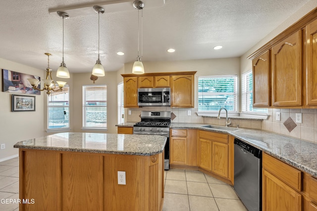 3081 Tierra Humeda Dr, El Paso, TX 79938 - kitchen with stainless steel appliances, a sink, a center island, light tile patterned floors, and a textured ceiling