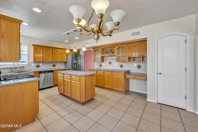 3081 Tierra Humeda Dr, El Paso, TX 79938 - kitchen featuring stainless steel appliances, a sink, a chandelier, light tile patterned floors, and tasteful backsplash