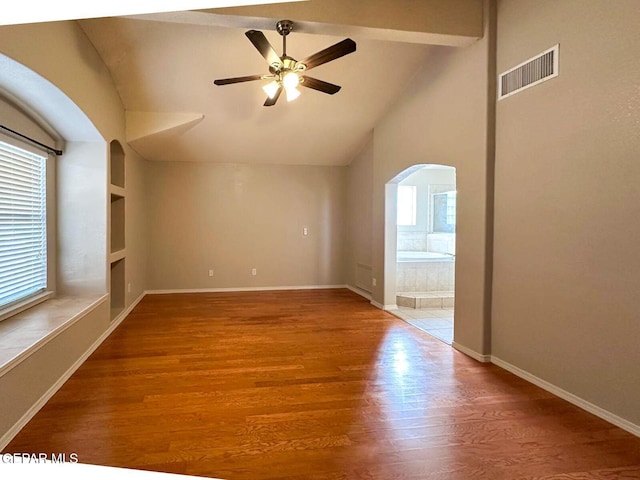 3081 Tierra Humeda Dr, El Paso, TX 79938 - empty room with arched walkways, a ceiling fan, wood finished floors, baseboards, and beamed ceiling