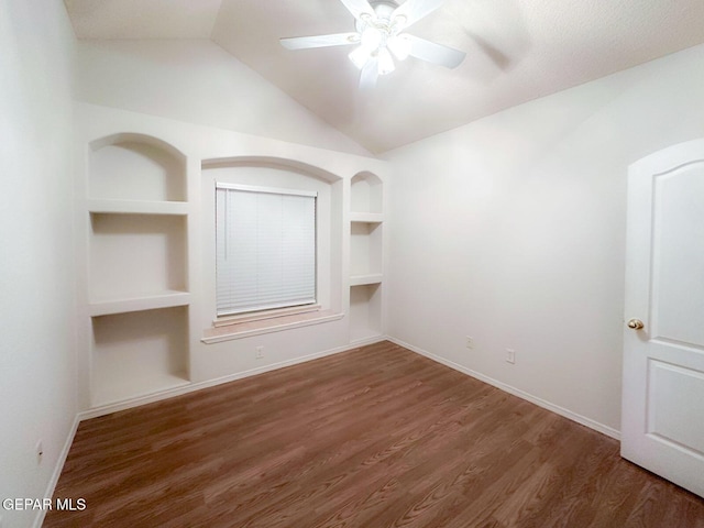 3081 Tierra Humeda Dr, El Paso, TX 79938 - spare room featuring built in shelves, ceiling fan, baseboards, wood finished floors, and vaulted ceiling