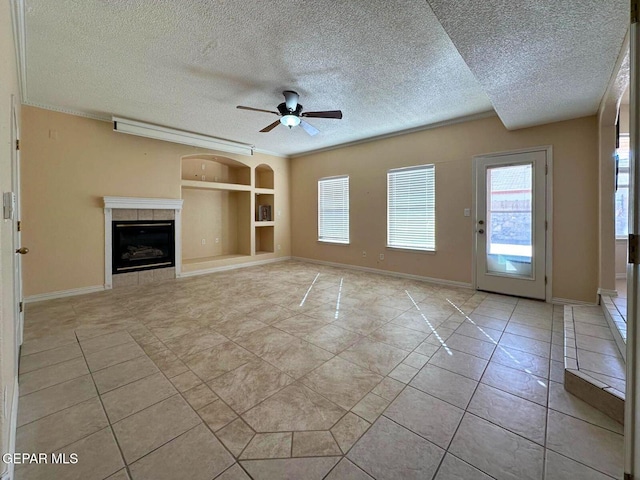 3081 Tierra Humeda Dr, El Paso, TX 79938 - unfurnished living room featuring a textured ceiling, built in shelves, healthy amount of natural light, ceiling fan, and light tile patterned floors