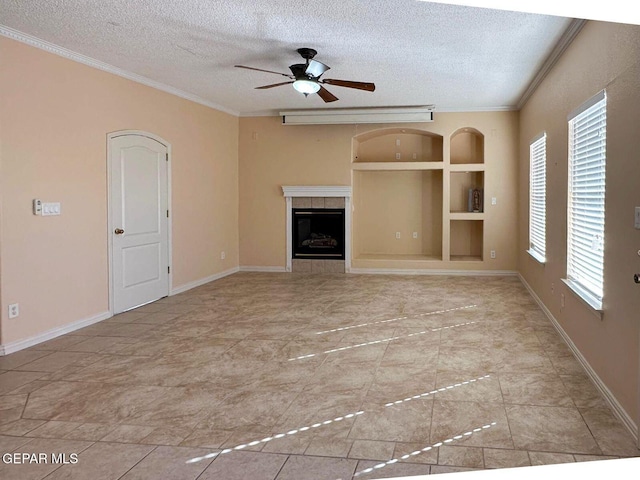 3081 Tierra Humeda Dr, El Paso, TX 79938 - unfurnished living room featuring ornamental molding, a textured ceiling, built in shelves, ceiling fan, and a tiled fireplace