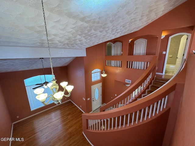 3081 Tierra Humeda Dr, El Paso, TX 79938 - stairway with a chandelier, vaulted ceiling, wood finished floors, and baseboards