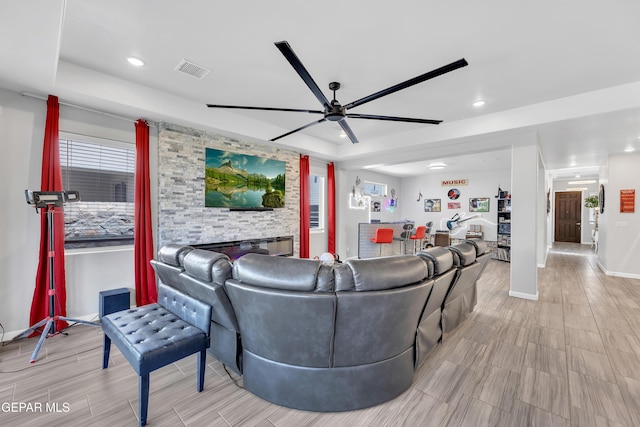 living room with a ceiling fan, a raised ceiling, baseboards, recessed lighting, and wood finish floors