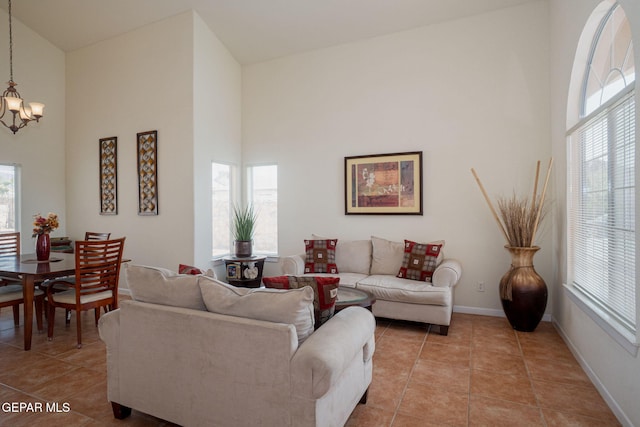 7350 Rosas Way, Canutillo, TX 79835 - living area with a chandelier, a high ceiling, plenty of natural light, light tile patterned floors, and baseboards