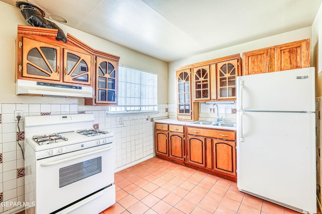 4209 Hercules Ave, El Paso, TX 79904 - kitchen featuring white appliances, under cabinet range hood, a sink, tile walls, and light tile patterned floors