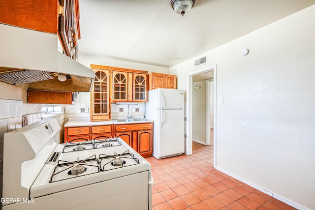4209 Hercules Ave, El Paso, TX 79904 - kitchen with white appliances, under cabinet range hood, a sink, brown cabinetry, and light countertops