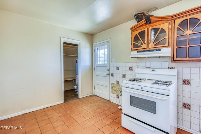 4209 Hercules Ave, El Paso, TX 79904 - kitchen with white gas range oven, under cabinet range hood, gas water heater, and light tile patterned flooring
