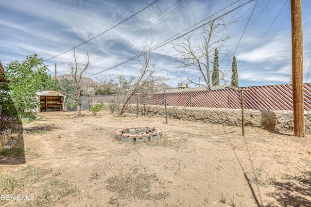 4209 Hercules Ave, El Paso, TX 79904 - fenced backyard featuring an outdoor fire pit and an outbuilding