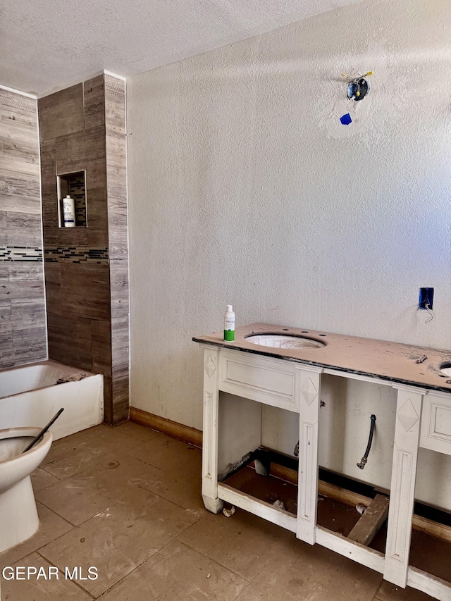 4500 Frankfort Ave, El Paso, TX 79903 - bathroom with toilet, a tub to relax in, vanity, a textured ceiling, and a textured wall