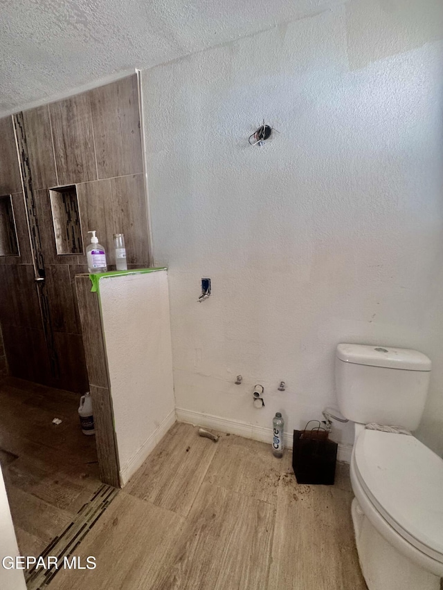 4500 Frankfort Ave, El Paso, TX 79903 - bathroom featuring toilet, wood finished floors, and baseboards