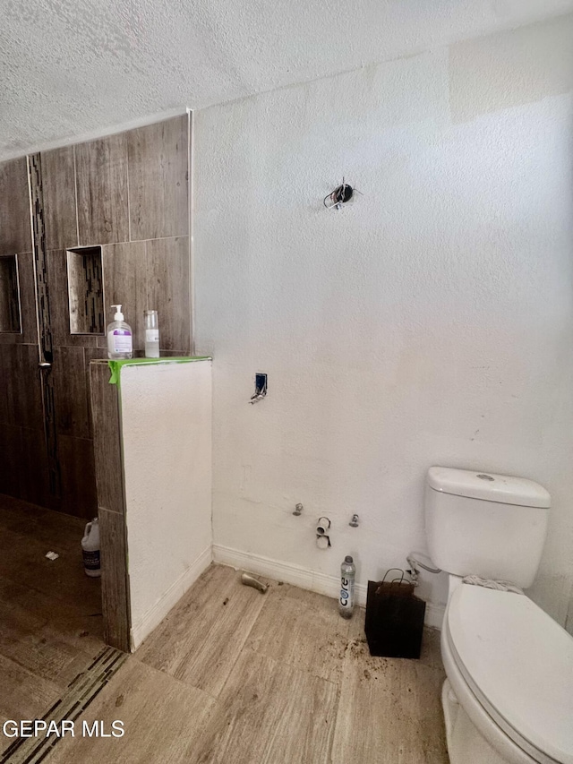 4500 Frankfort Ave, El Paso, TX 79903 - bathroom featuring toilet, wood finished floors, a textured ceiling, and baseboards