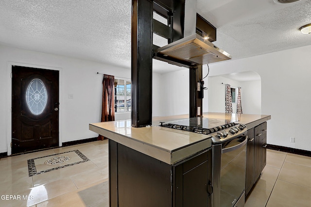 5713 Sanders Ave, El Paso, TX 79924 - kitchen featuring electric range, a textured ceiling, light tile patterned floors, arched walkways, and baseboards