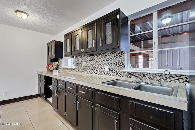 5713 Sanders Ave, El Paso, TX 79924 - kitchen featuring backsplash, a sink, light countertops, baseboards, and light tile patterned floors