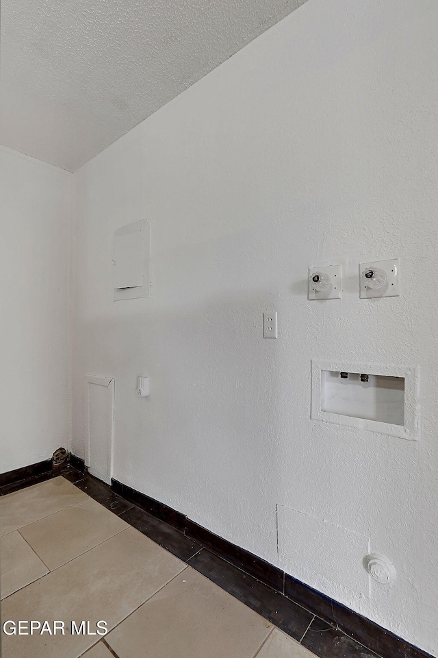 5713 Sanders Ave, El Paso, TX 79924 - laundry room with tile patterned floors, baseboards, and a textured ceiling
