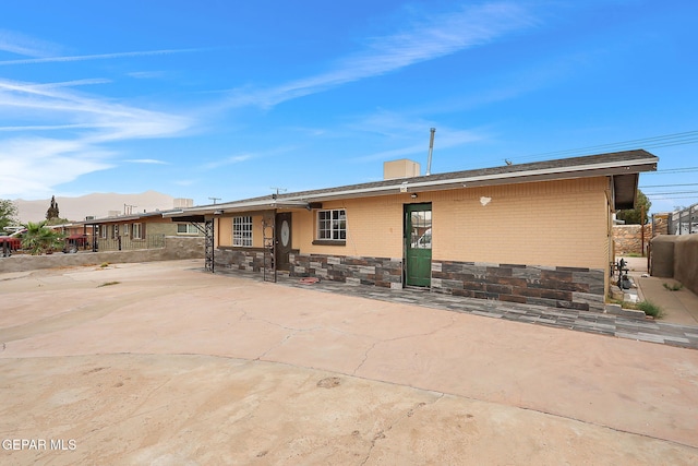 5713 Sanders Ave, El Paso, TX 79924 - back of property featuring brick siding, a mountain view, fence, and stone siding