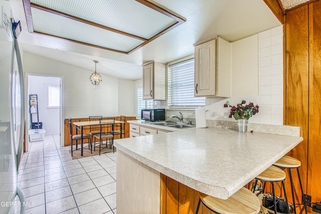 5137 Edmonton Ave, El Paso, TX 79924 - kitchen featuring black microwave, light countertops, healthy amount of natural light, and a peninsula