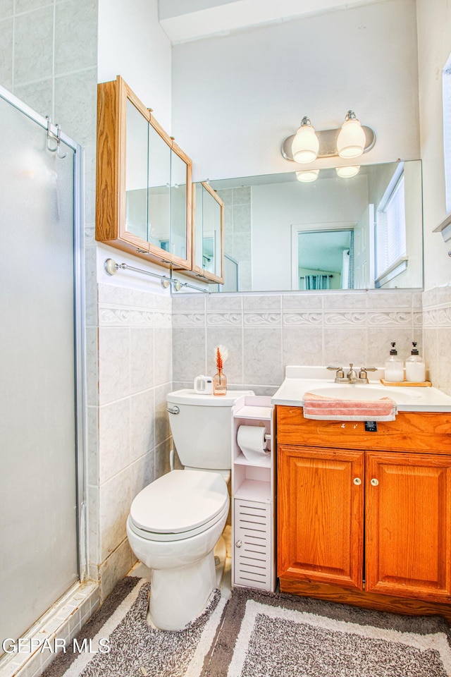 5137 Edmonton Ave, El Paso, TX 79924 - full bathroom with tile walls, a shower stall, vanity, and wainscoting