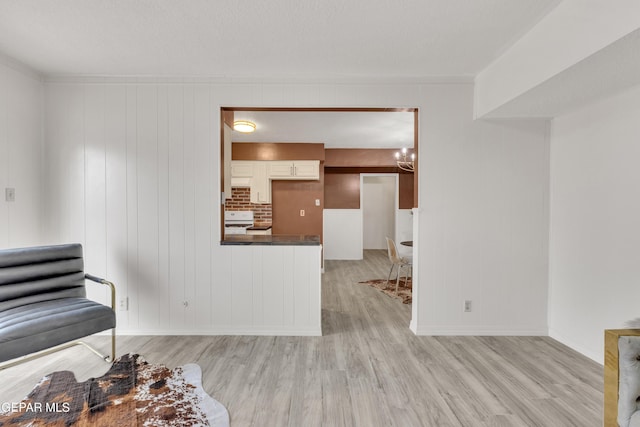 sitting room with light wood finished floors, a chandelier, and baseboards