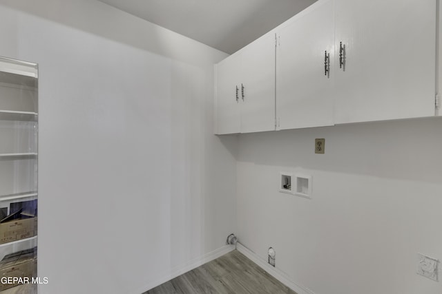 laundry area featuring cabinet space, hookup for a washing machine, wood finished floors, and baseboards