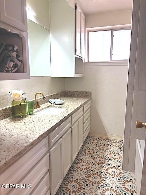 bathroom featuring vanity, baseboards, and tile patterned flooring