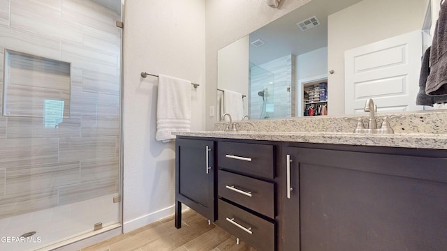 569 Logwood Ave, Canutillo, TX 79835 - full bath featuring a stall shower, double vanity, a spacious closet, wood finished floors, and baseboards