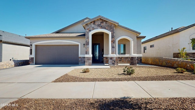 569 Logwood Ave, Canutillo, TX 79835 - view of front of house featuring stone siding, an attached garage, concrete driveway, and stucco siding