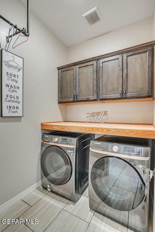 14809 Tierra Escape Ave, El Paso, TX 79938 - laundry area featuring washing machine and clothes dryer, cabinet space, wood finish floors, and baseboards
