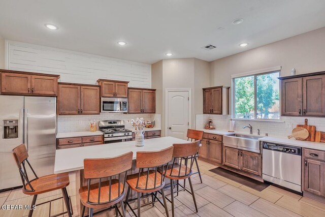 14809 Tierra Escape Ave, El Paso, TX 79938 - kitchen with appliances with stainless steel finishes, decorative backsplash, a sink, a kitchen breakfast bar, and recessed lighting