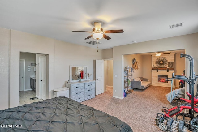 14809 Tierra Escape Ave, El Paso, TX 79938 - carpeted bedroom featuring a glass covered fireplace, ensuite bathroom, baseboards, and ceiling fan