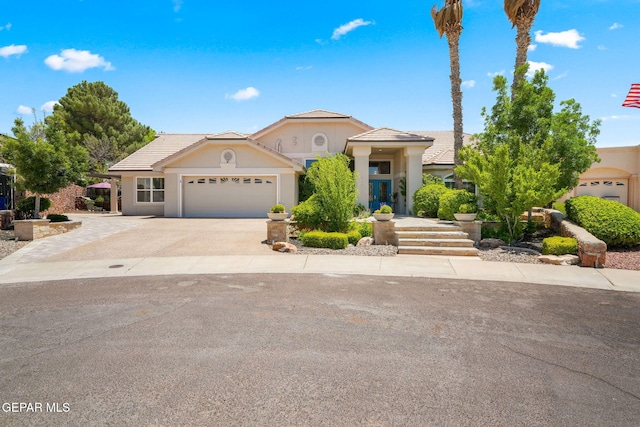 12081 E Paseo De Amor Ln E, El Paso, TX 79936 - view of front of home featuring an attached garage, a tile roof, driveway, and stucco siding