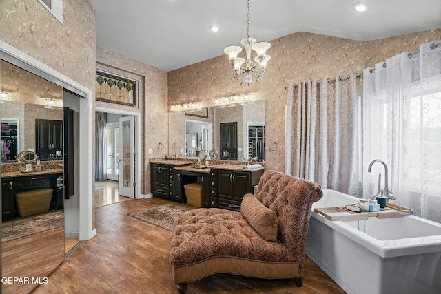 12081 E Paseo De Amor Ln E, El Paso, TX 79936 - bathroom with hardwood / wood-style floors, a freestanding tub, lofted ceiling, a chandelier, and vanity