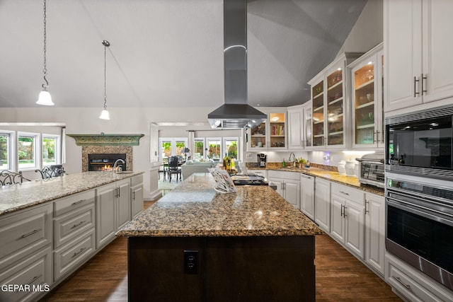 12081 E Paseo De Amor Ln E, El Paso, TX 79936 - kitchen featuring oven, vaulted ceiling, extractor fan, light stone countertops, and white cabinetry