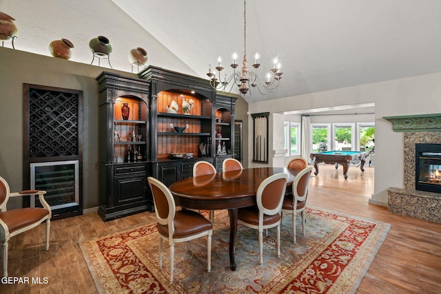12081 E Paseo De Amor Ln E, El Paso, TX 79936 - dining space featuring beverage cooler, lofted ceiling, billiards, light wood-style floors, and a high end fireplace