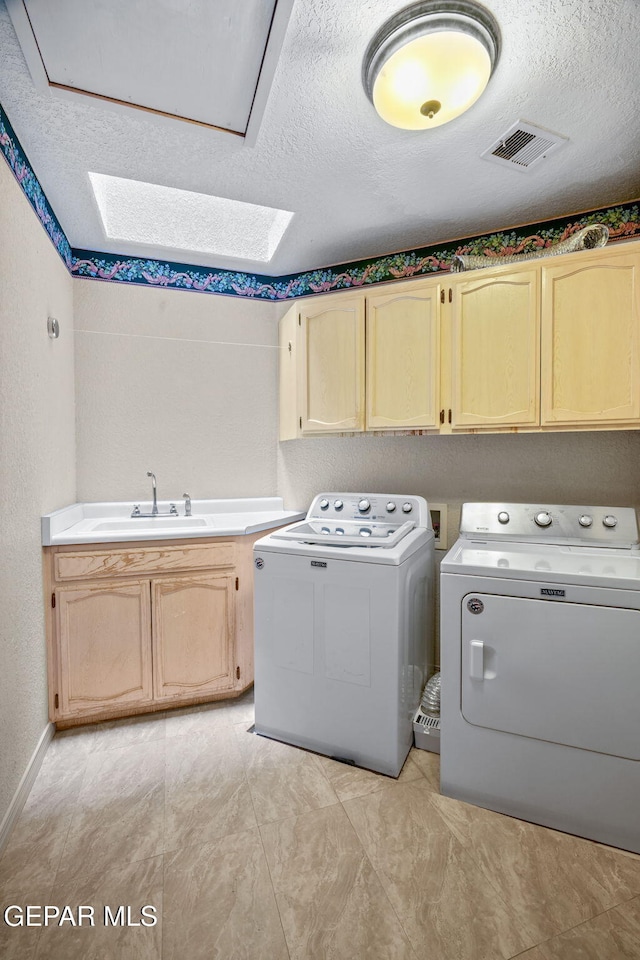 12081 E Paseo De Amor Ln E, El Paso, TX 79936 - laundry room featuring cabinet space, washer and dryer, a skylight, a textured ceiling, and baseboards