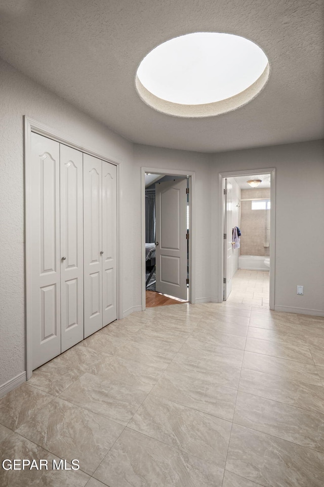 12081 E Paseo De Amor Ln E, El Paso, TX 79936 - unfurnished bedroom featuring baseboards, a closet, a textured ceiling, and ensuite bathroom