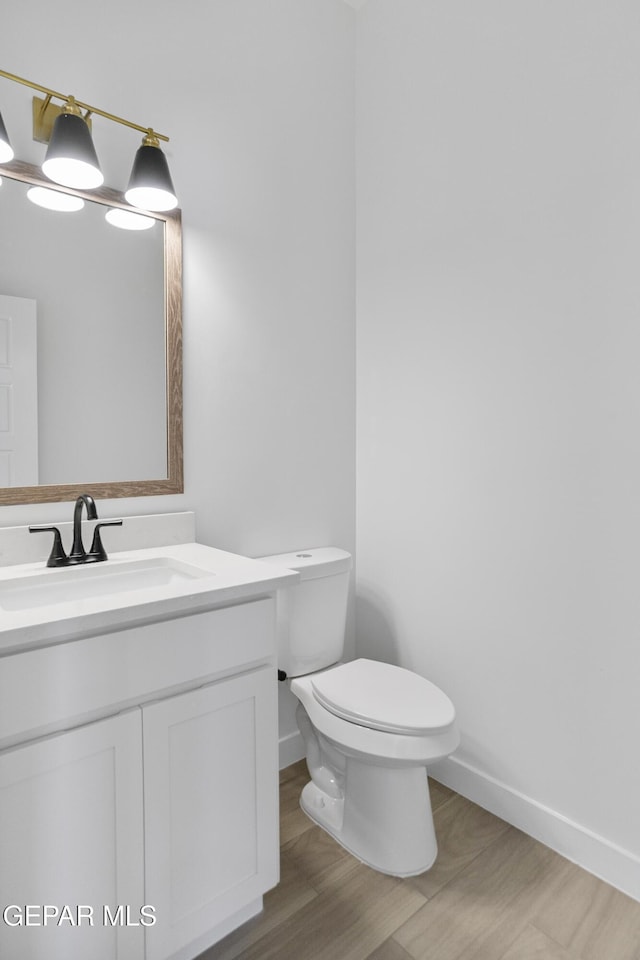 10700 Elise St, El Paso, TX 79924 - half bath featuring toilet, wood finished floors, vanity, and baseboards