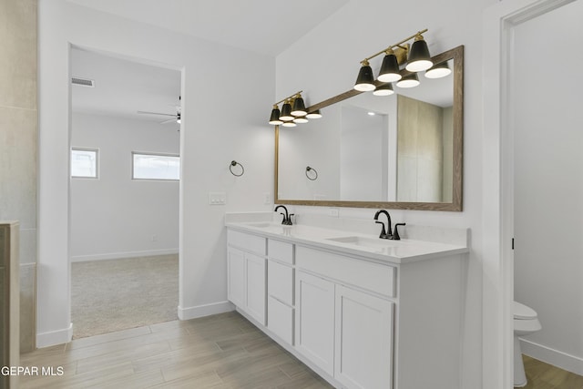 10700 Elise St, El Paso, TX 79924 - full bath with double vanity, ceiling fan, toilet, and wood finished floors