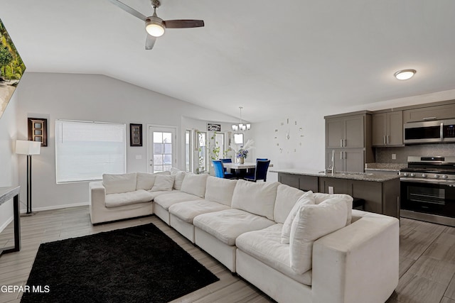 13804 Flora Vista Ave, Horizon City, TX 79928 - living room featuring ceiling fan, vaulted ceiling, light wood-style floors, and baseboards