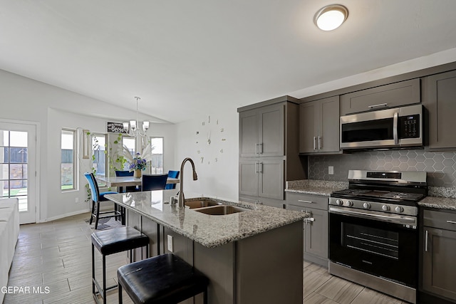 13804 Flora Vista Ave, Horizon City, TX 79928 - kitchen with appliances with stainless steel finishes, a sink, lofted ceiling, tasteful backsplash, and light stone counters