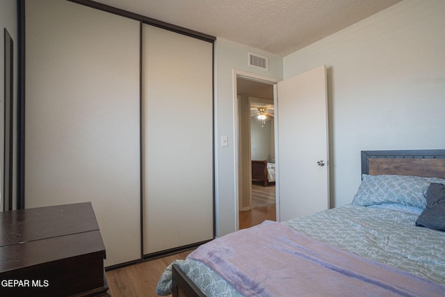 1662 Gene Torres Dr, El Paso, TX 79936 - bedroom with wood finished floors, a textured ceiling, and a closet
