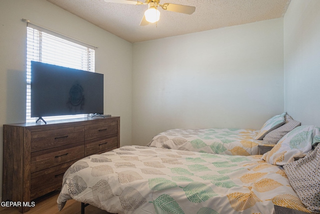 1662 Gene Torres Dr, El Paso, TX 79936 - bedroom featuring a textured ceiling, a ceiling fan, and wood finished floors