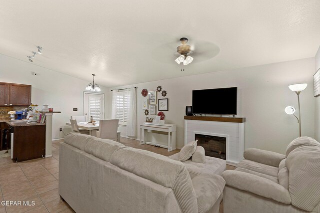 14239 Trigger Rock Ln, El Paso, TX 79938 - living area featuring light tile patterned flooring, a chandelier, ceiling fan, and a fireplace
