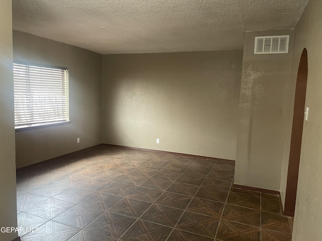 8324 Diana Dr, El Paso, TX 79904 - unfurnished room with arched walkways and a textured ceiling