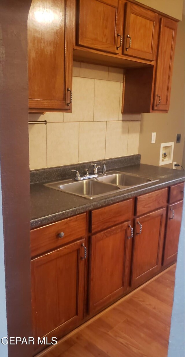 8324 Diana Dr, El Paso, TX 79904 - kitchen featuring a sink, brown cabinetry, dark countertops, and light wood-type flooring