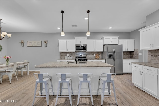 14953 Willie Worsley Ave, El Paso, TX 79938 - kitchen featuring stainless steel appliances, decorative backsplash, an island with sink, white cabinets, and recessed lighting