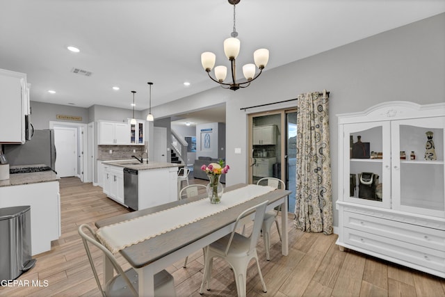 14953 Willie Worsley Ave, El Paso, TX 79938 - dining room with stairway, light wood finished floors, a chandelier, and recessed lighting