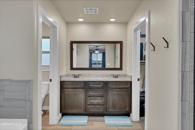 14953 Willie Worsley Ave, El Paso, TX 79938 - full bathroom with wood finished floors, toilet, double vanity, and ceiling fan
