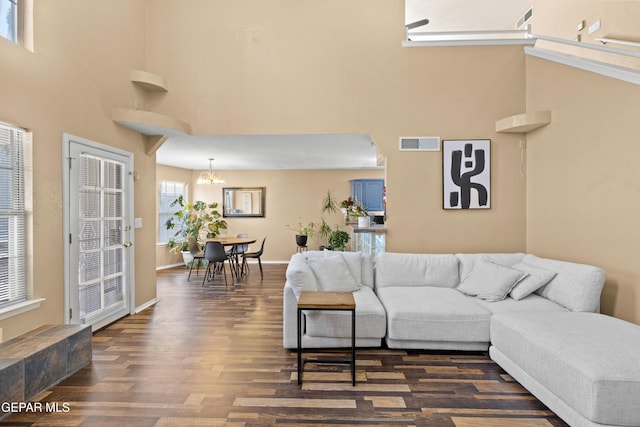 7107 Desert Jewel Dr, El Paso, TX 79912 - living area with dark wood finished floors, a towering ceiling, a chandelier, and baseboards