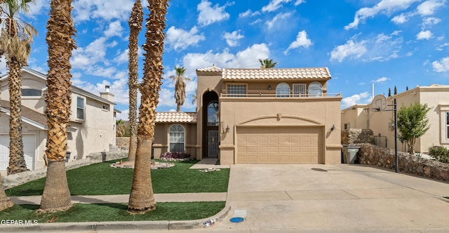 7107 Desert Jewel Dr, El Paso, TX 79912 - mediterranean / spanish home with a tile roof, a balcony, stucco siding, concrete driveway, and an attached garage